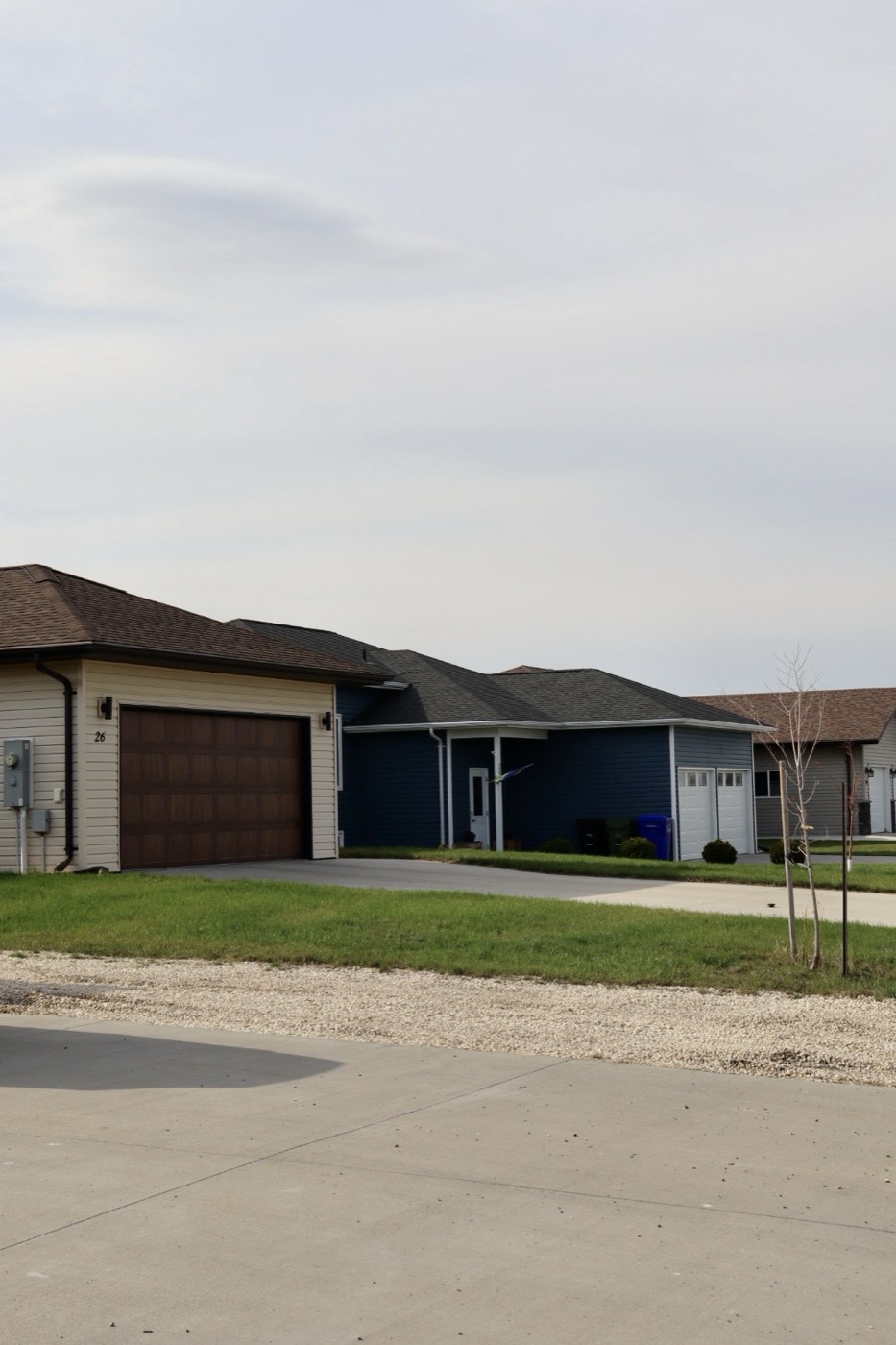 Heritage Porch Home: custom blue home featuring a brown garage door